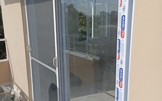 Balkon kapısına takılan sürme sineklik ve beyaz PVC sürme kapı