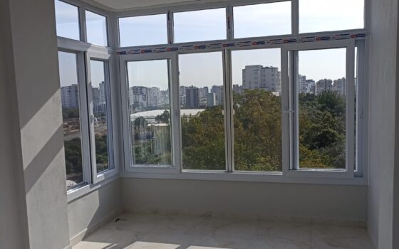 Beyaz PVC pencerelerle kapatılmış köşe balkon uygulaması