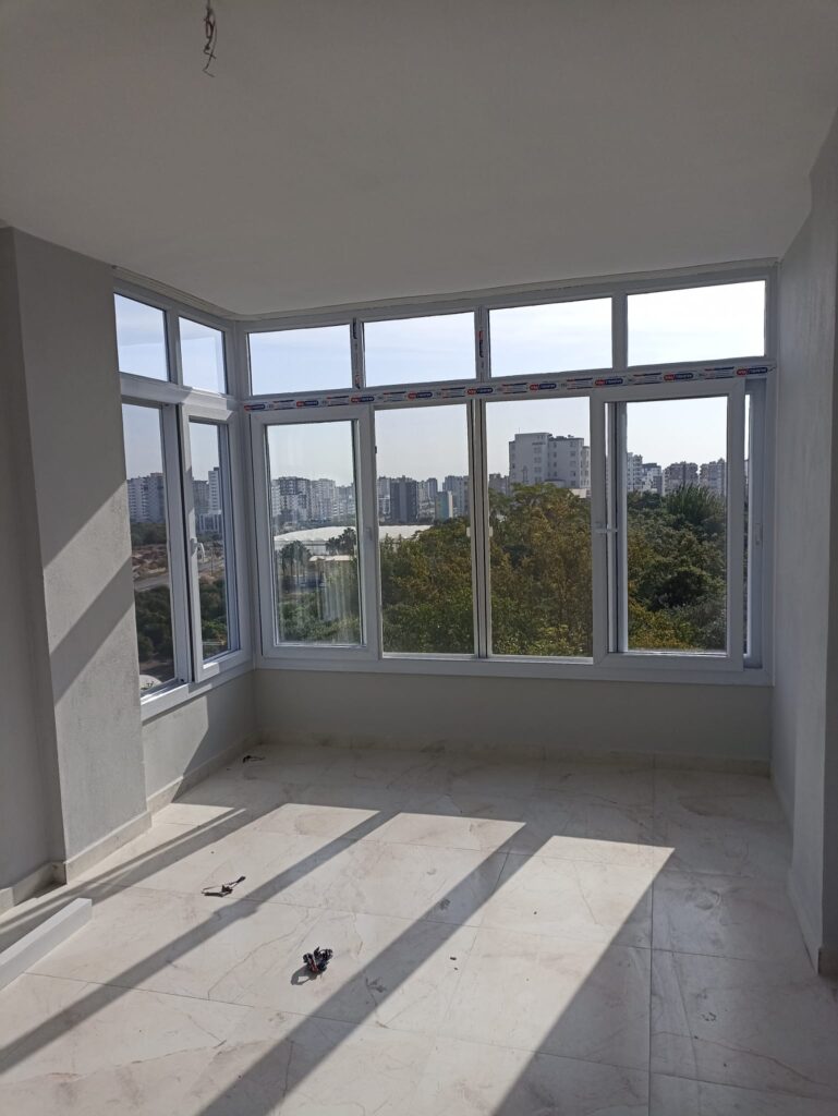 Beyaz PVC pencerelerle kapatılmış köşe balkon uygulaması
