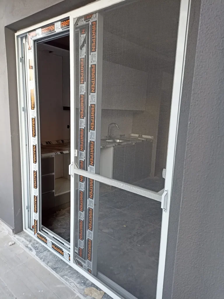 Koruyucu bandı üzerinde yeni beyaz PVC kapı ve sineklik montajı
